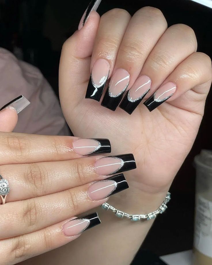 Chic Long Nails: Bold Black Tips with Elegant Nude and Silver Glitter Accents.