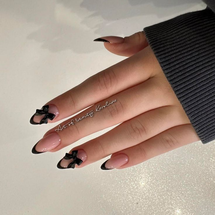 Chic Almond-Shaped Nails with Nude and Black Colors Enhanced by Elegant Black Bows.