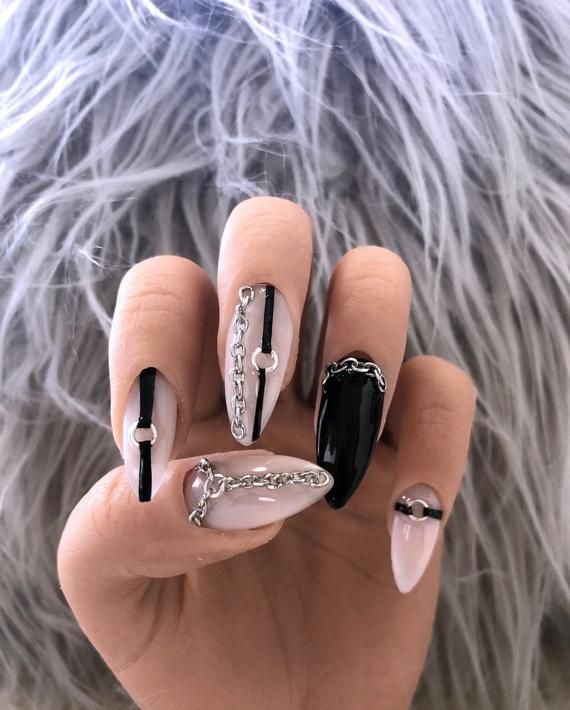 Edgy Black and Nude Nail Design with Metallic Chains and Contrasting Finishes.