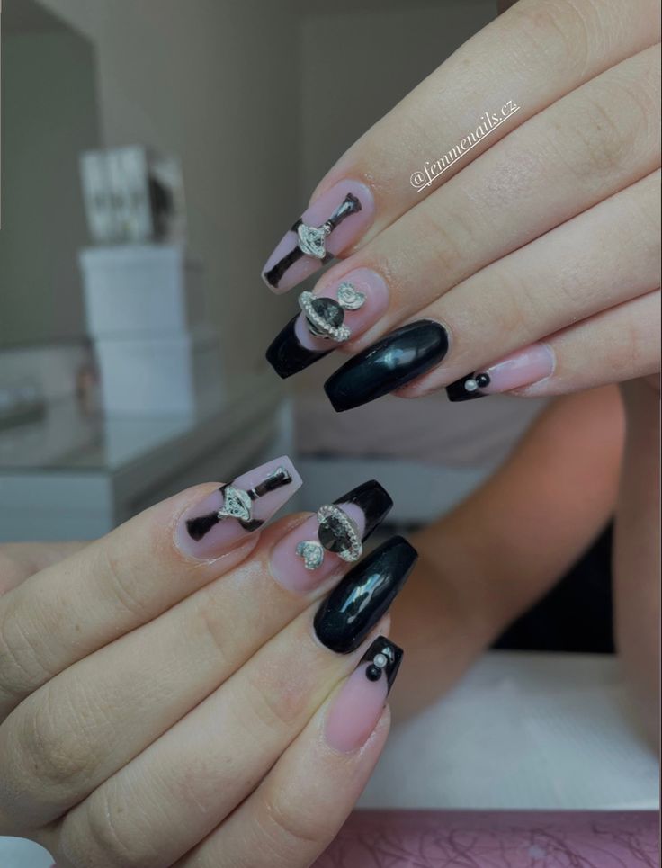 Chic Elegant Nail Design: Striking Black and Nude Polish with Rhinestones and Intricate Patterns.