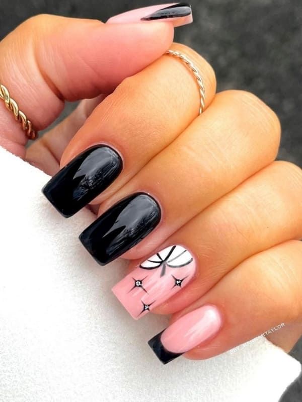 Elegant Edgy Nail Design: Bold Black Meets Soft Pink with Floral Accent.