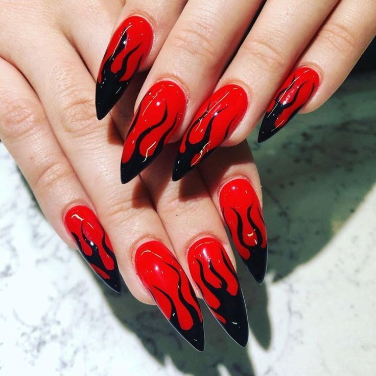 Dramatic Flame-Inspired Angular Stiletto Nail Design in Vibrant Red and Deep Black.