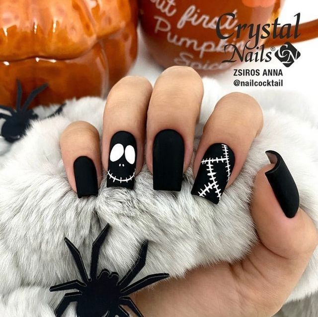 Spooky Stylish Halloween Nail Design with Matte Black Finish and Playful Accents.