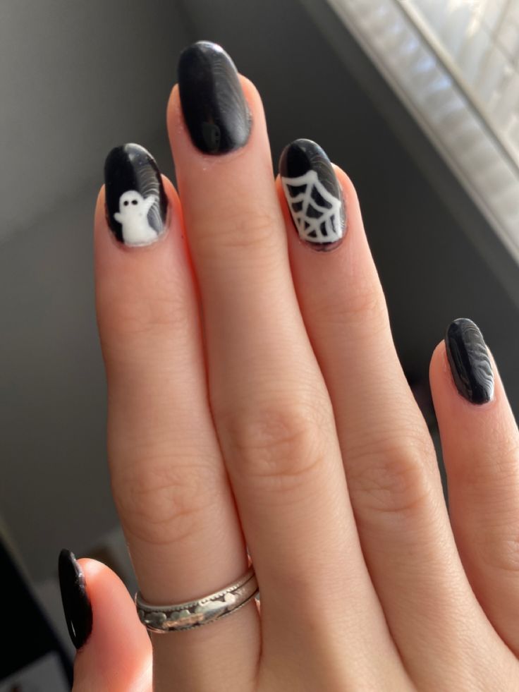 Whimsical Halloween Nail Art with Sleek Black Base and Playful Motifs.