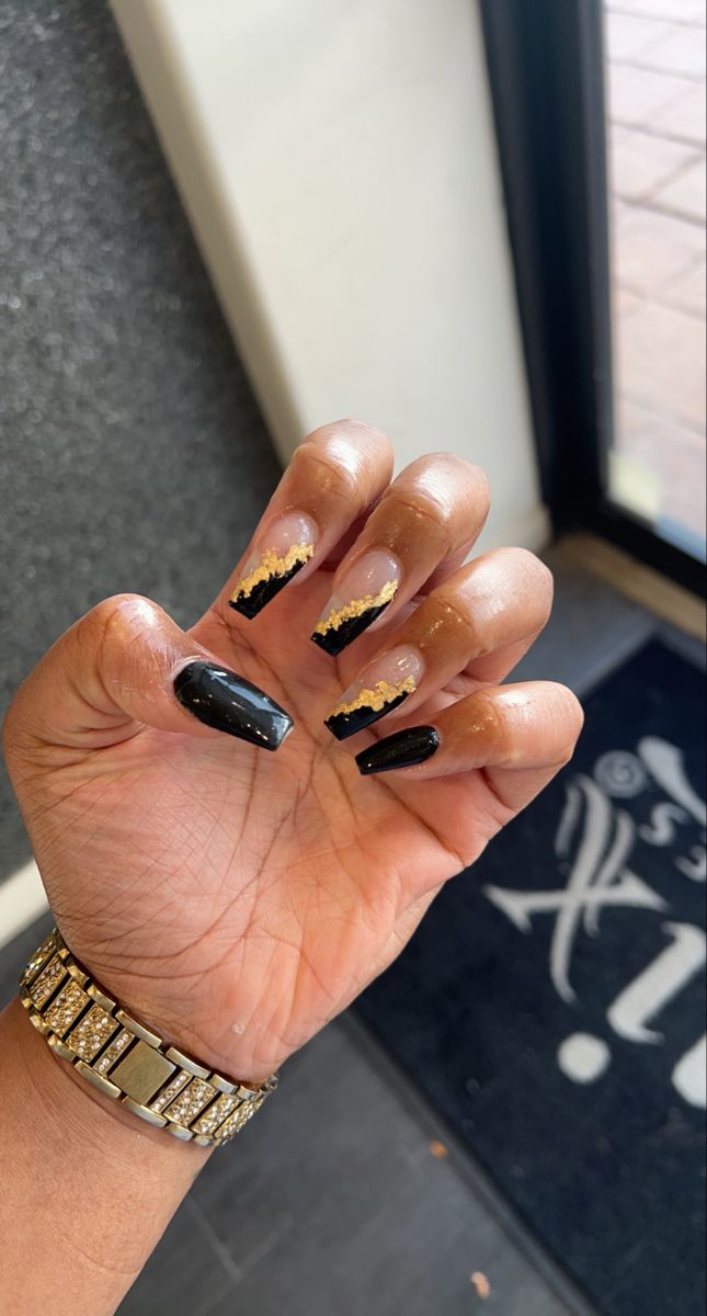 Elegant Black and Nude Nail Design with Gold Detailing for a Sophisticated Modern Look.