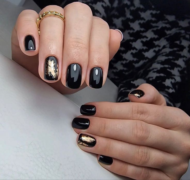 Chic Elegant Black Nail Design with Glossy Finish and Delicate Gold Accents.