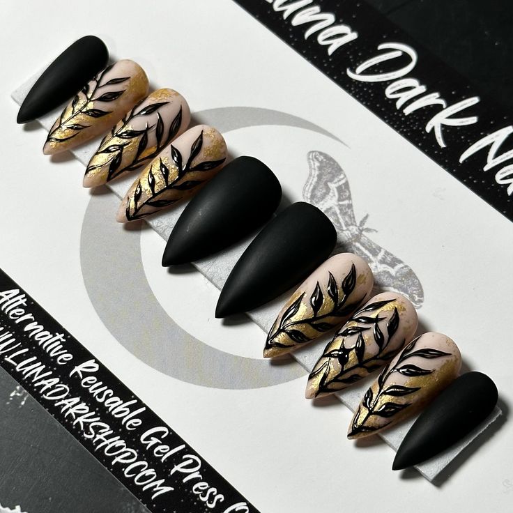 Sophisticated Nail Design: Matte Black and Soft Nude with Leafy Gold Accents.