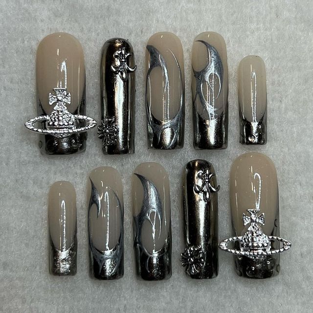 Sophisticated Chic Nail Set: Elegant Nude and Black Hues with Glamorous Silver Embellishments and Marble Swirls.