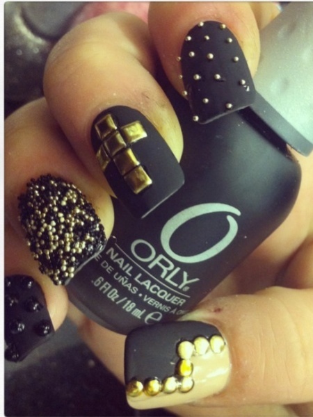 Bold Black Matte Nail Design with Shimmering Gold Accents and Textural Variety.