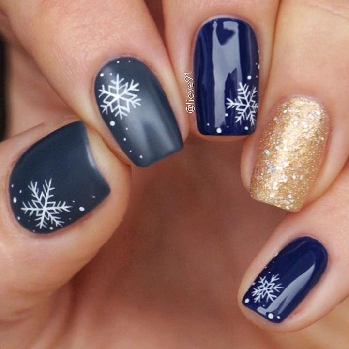 Winter-Themed Nail Design with Dark Navy, Gold Sparkles, and Elegant Snowflakes.