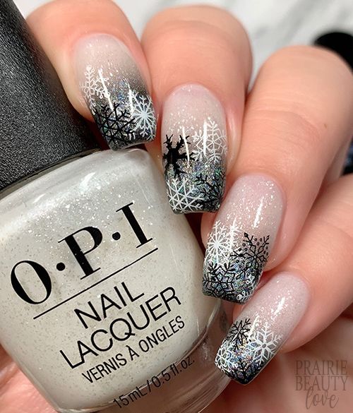 Elegant Winter-Inspired Nail Design: Gradient Pink to Black with Festive Snowflakes and Reindeer Patterns.