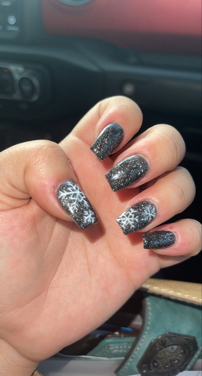 Elegant Winter Nail Design: Dark Sparkly Polish with Delicate Snowflake Accents