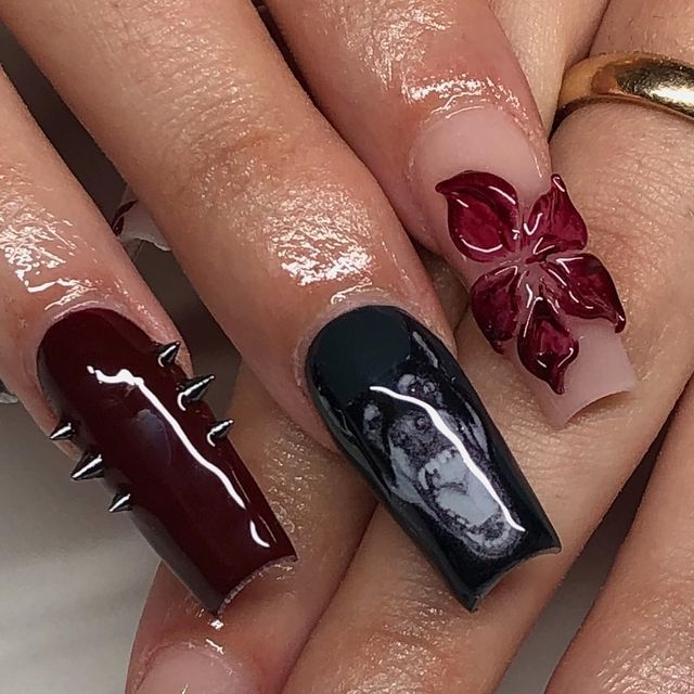 Striking Dark Burgundy and Black Nail Design with Metallic Spikes and 3D Floral Accents.