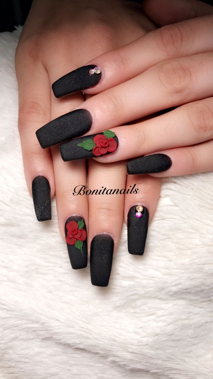 Elegant Matte Black Nail Design with Detailed Red Roses and Sparkling Rhinestones.