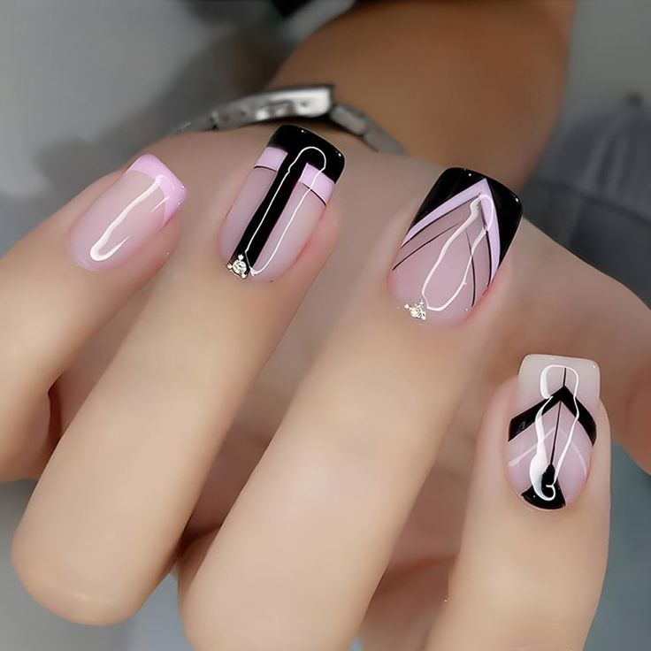 Modern Chic Nail Art: Elegant Soft Pink and Bold Black with Geometric Patterns and Gem Accents.