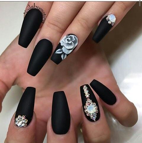 Elegant Matte Black Nails with White Floral Accents and Gemstone Glamour.