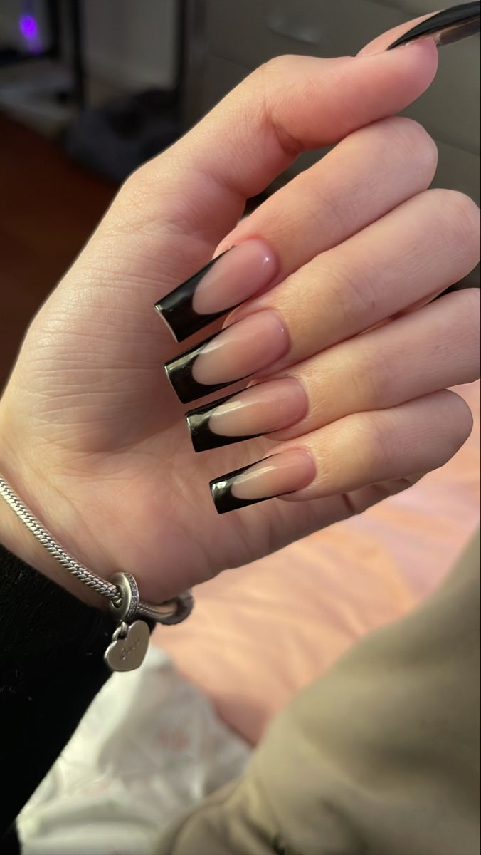 Chic Gradient Nail Design: Striking Black Tips on Natural Nude Base.