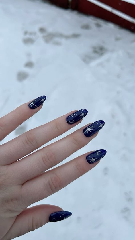 Elegant Starry Night Nail Design: Deep Blue Polish with White Starbursts and Crescent Moons.