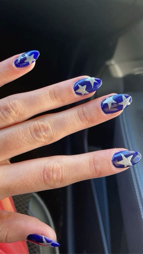 Glossy Blue Nail Art with Silver Star Motifs for a Playful, Festive Look.