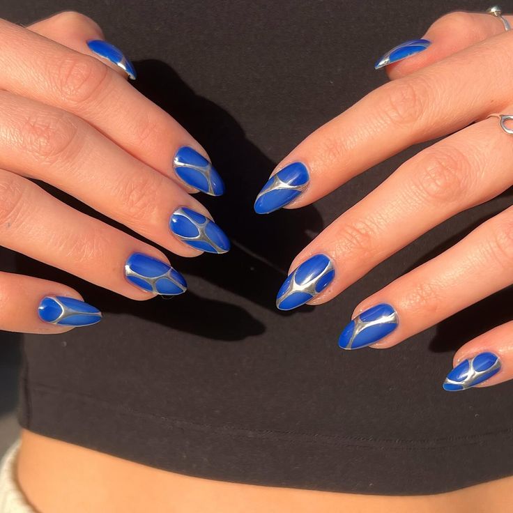 Bold Blue Manicure with Geometric White Accents on Almond-Shaped Nails.