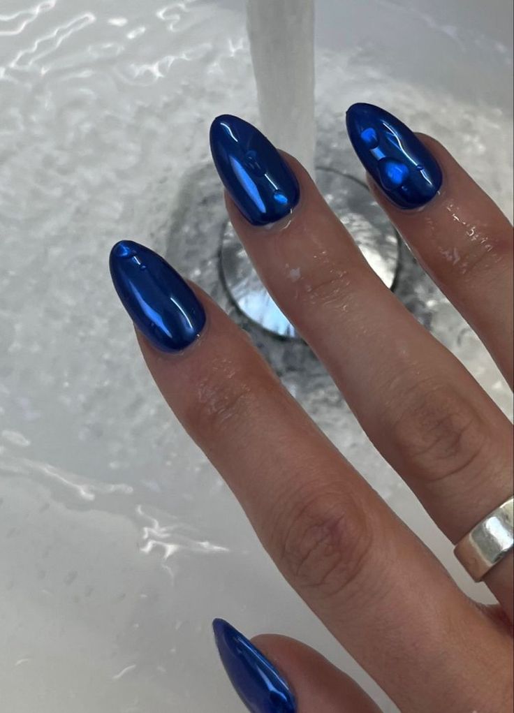 Elegant Vibrant Blue Nail Design with Glossy Finish and Minimalistic Silver Ring.