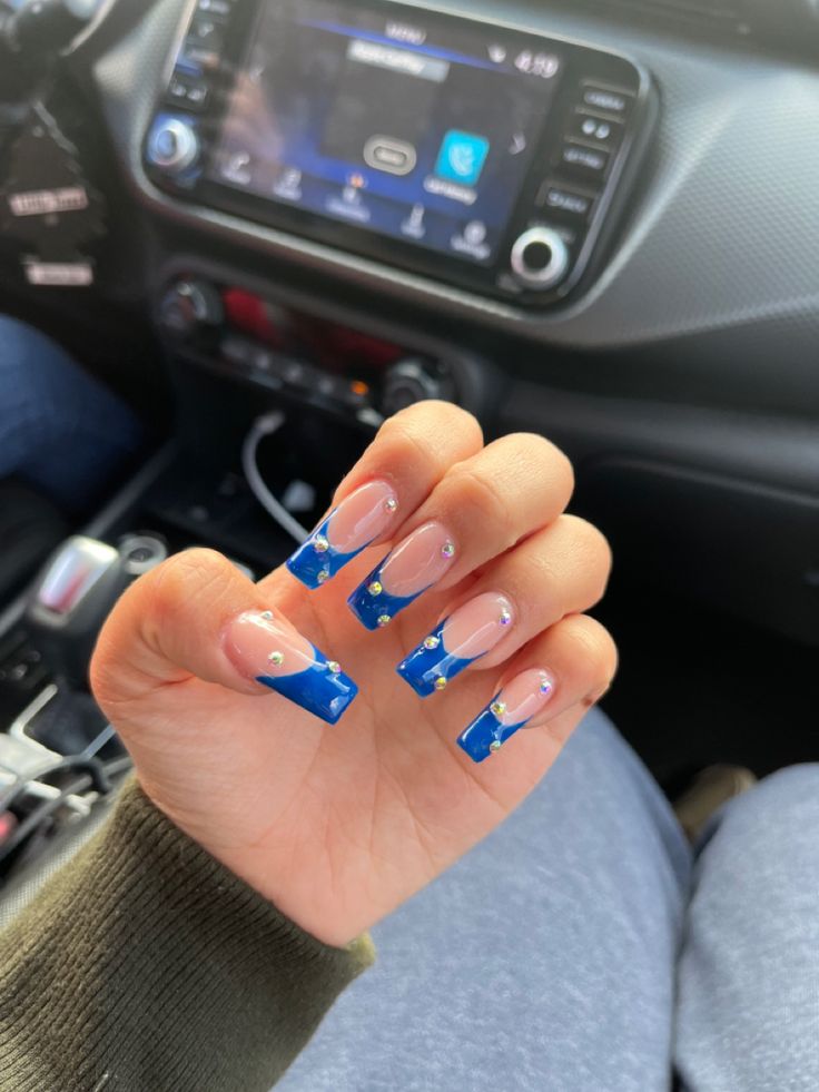 Elegant Glossy Blue French Tip Nails with Subtle Embellishments for a Chic Look.