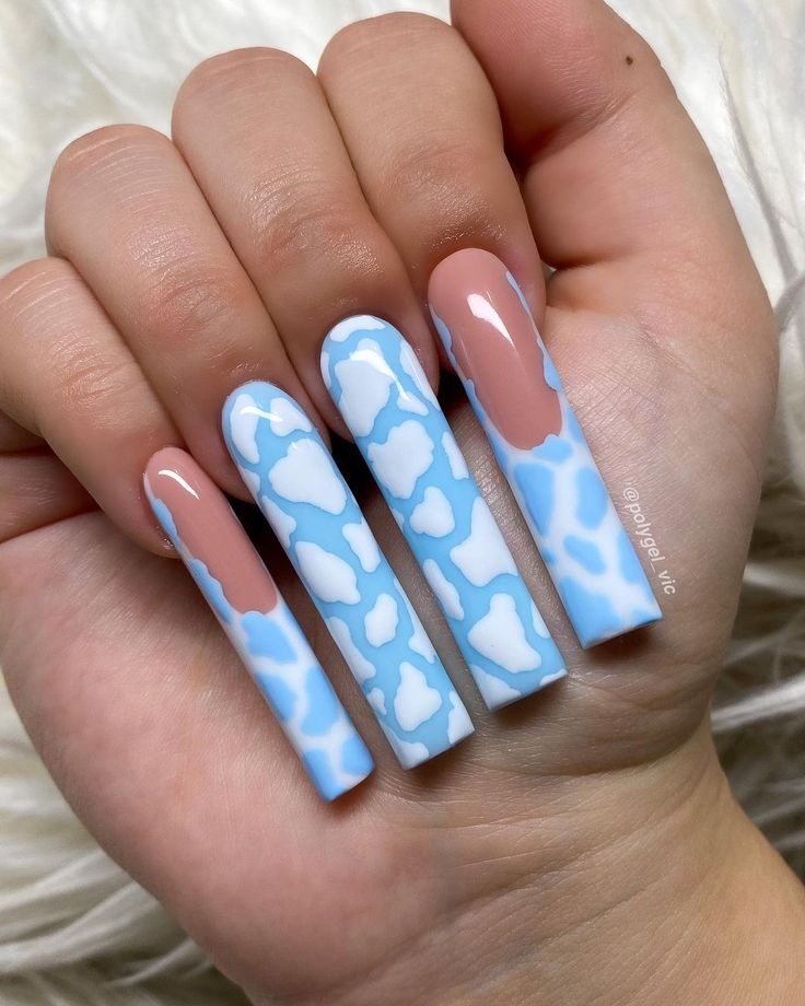 Whimsical Light Blue Cloud Nail Design with Sophisticated Nude Accents and Long, Creative Tips.