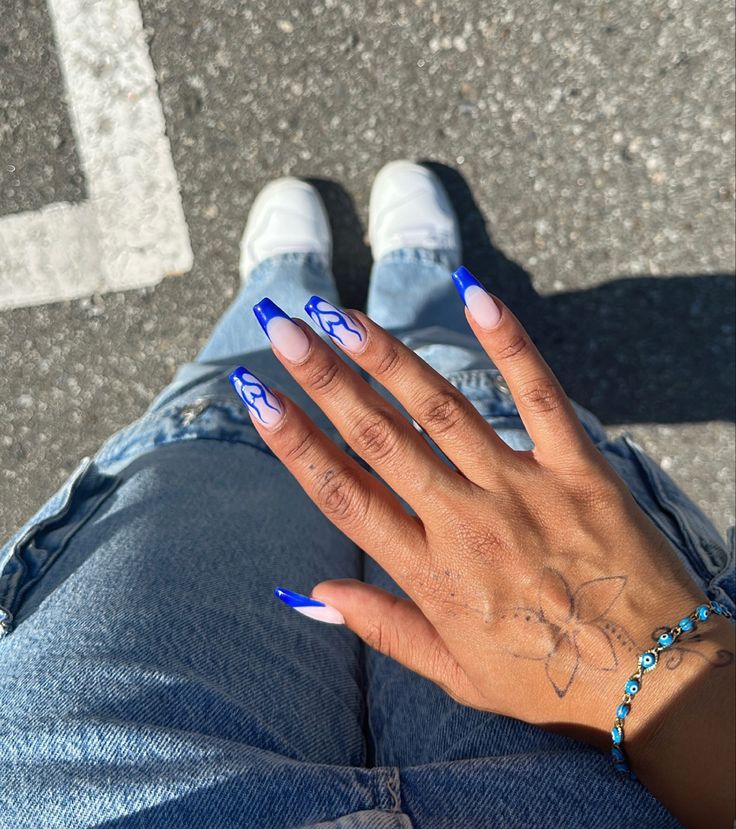 Chic Blue Nail Design with Elegant White Swirls for a Playful Yet Stylish Look.