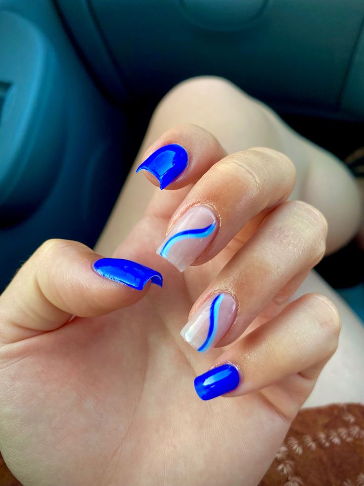 Striking Vibrant Blue Nail Design Blending Solid Colors and Artistic Lines for Sophisticated Elegance.