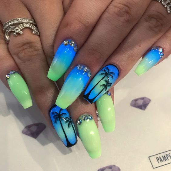 Tropical Ombre Nail Design: Bright Blue to Green Gradient with Palm Tree Silhouettes and Sparkling Rhinestones for a Bold Summer Look.