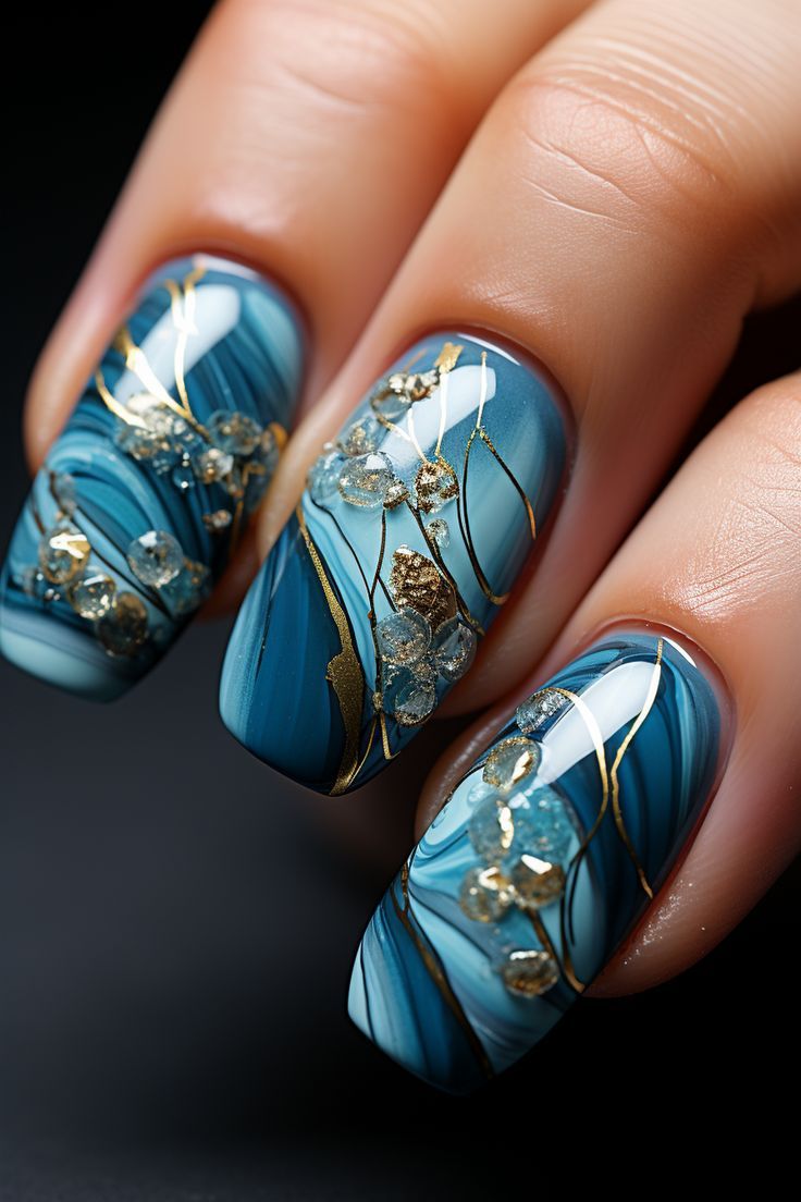 Elegant Blue Water-Inspired Nail Design with Gold Accents and Floral Details