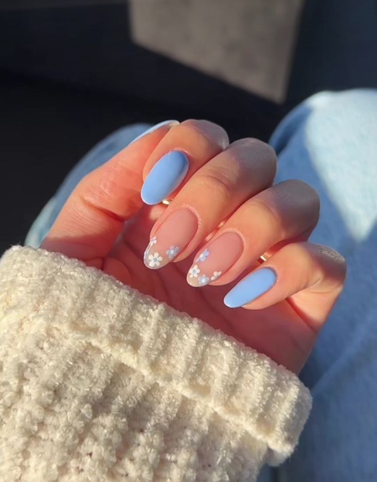 Chic Pastel Blue and Nude Nail Design with Floral Accents and Mixed Finishes.