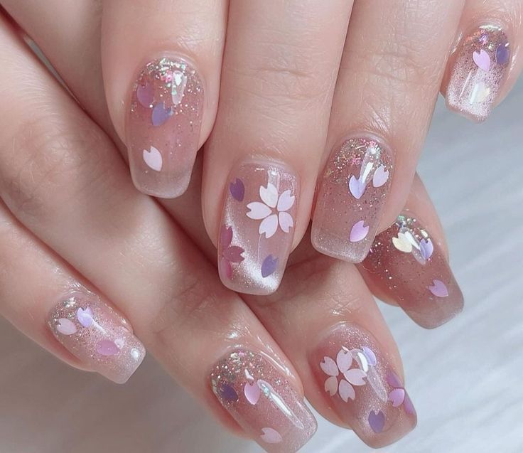 Elegant Floral Nail Design with Cherry Blossom, Heart Patterns, and Sparkling Gradient for Spring.