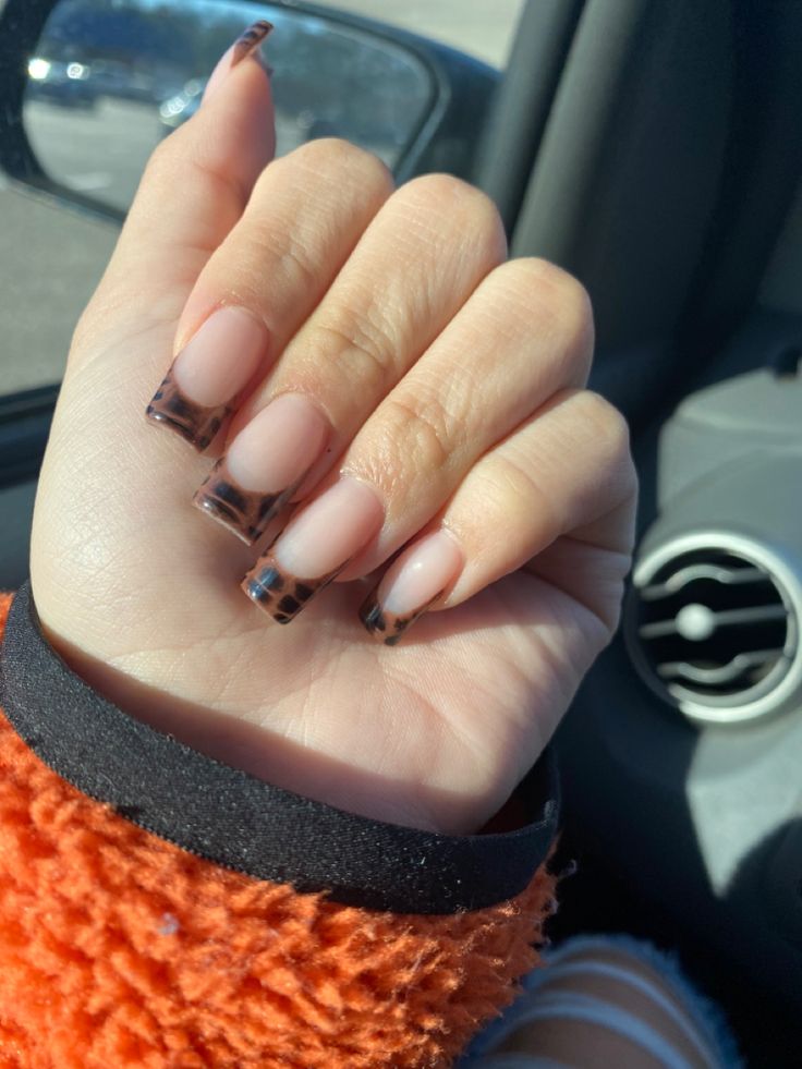 Chic French Tip Nail Design with Bold Animal Print for a Trendy Look.