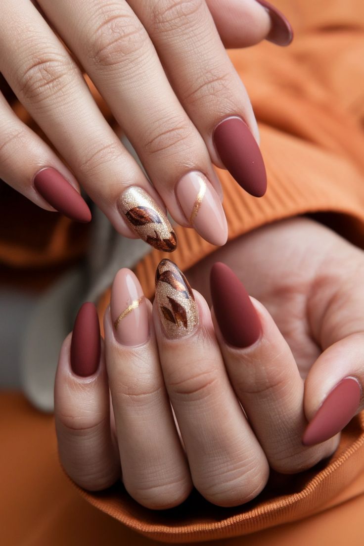 Chic Autumn Nail Design: Matte Burgundy and Glossy Nude with Gold Leaf Accents