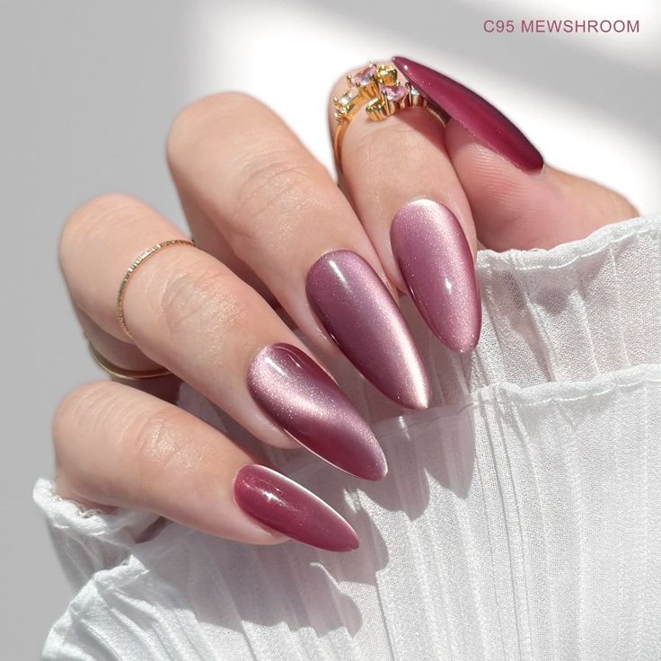 Sophisticated Almond-Shaped Burgundy and Soft Pink Nail Design with Glamorous Rings.