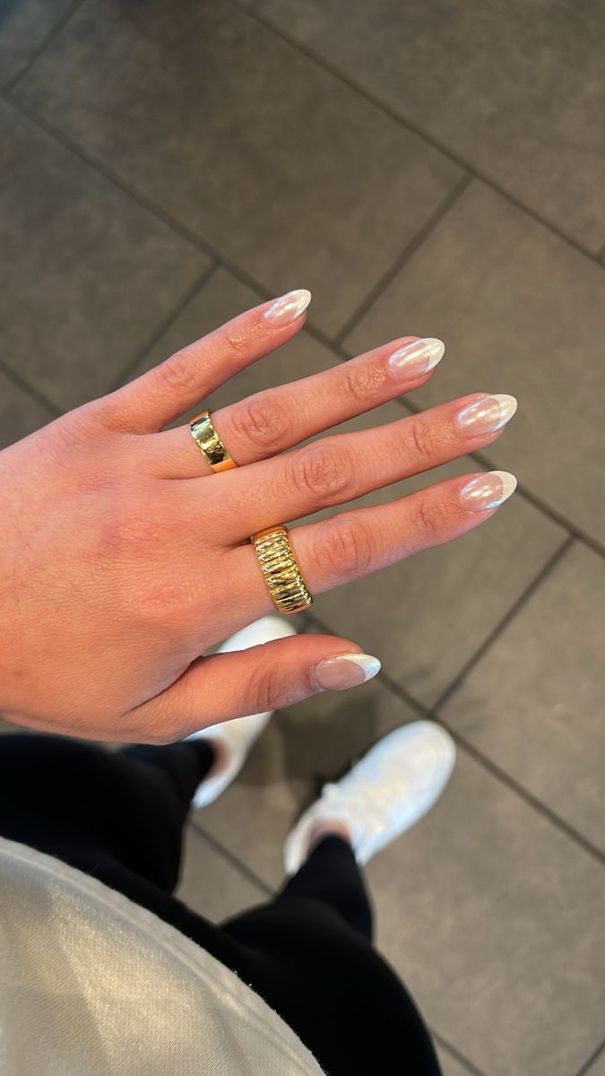 Chic Almond-Shaped Nails with Glossy Pink Base and White Tips, Accented by Gold Rings.