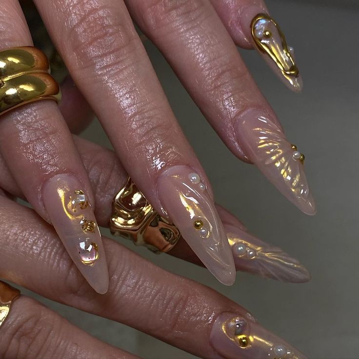 Luxurious Elongated Nude Stiletto Nails with Metallic Gold and Pearl Accents