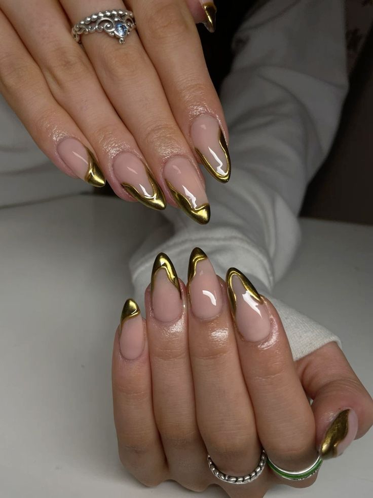 Chic Almond-Shaped Nails with Metallic Gold Tips and Glamorous Accents.