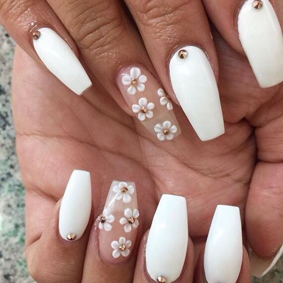 Elegant White Nails with Floral Accents and Gold Studs for a Sophisticated Look.