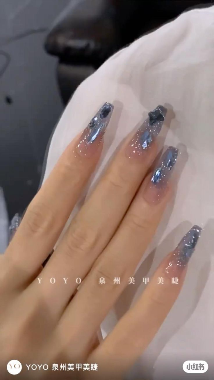 Elegant Icy Blue and Silver Gradient Nail Design with Pointed Tips and Sparkling Accents.