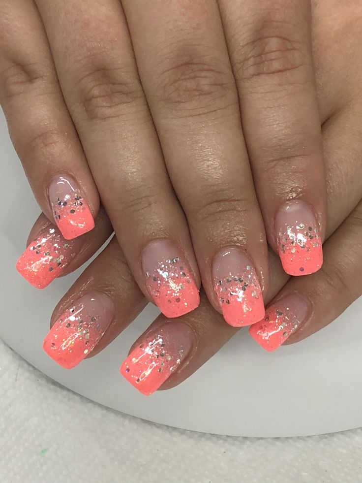 Striking Vibrant Coral Ombre Nails with Glitter Accents for Festive Looks.