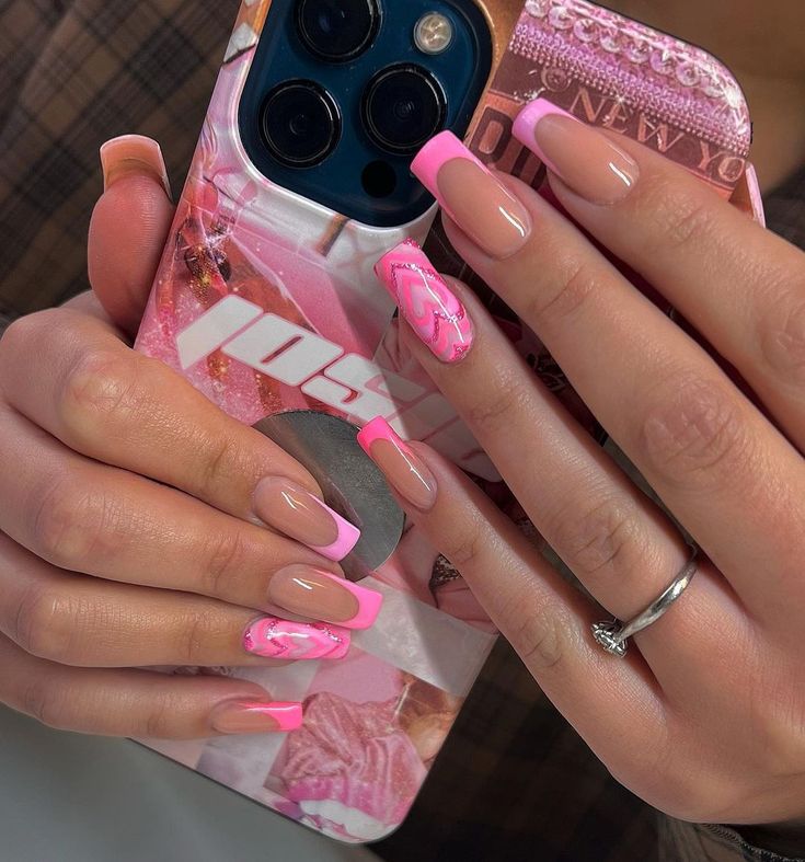 Modern and Playful Nail Design: Soft Nude and Vibrant Pink with Elegant French Tips and Swirling Patterns.