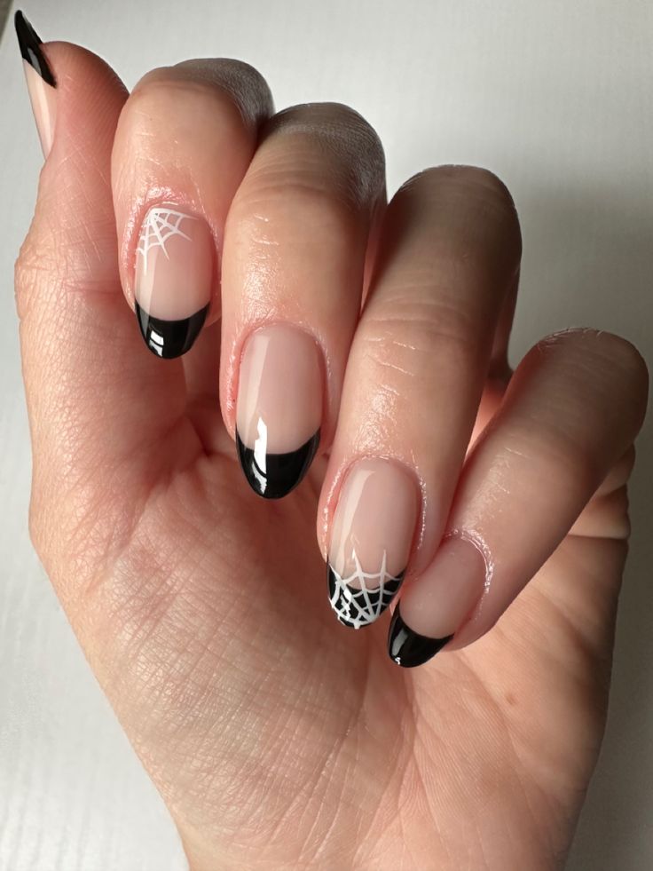 Chic Halloween Nail Design: Elegant Black French Tips with Playful Spider Web Motifs.