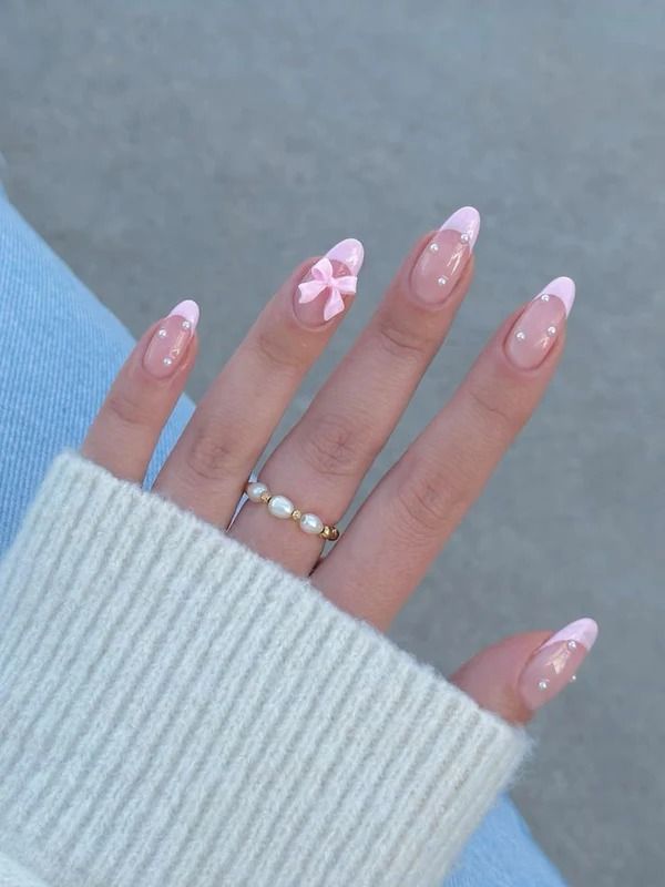 Elegant Pink and Nude Nail Design with 3D Bow Accents and Pearl Jewelry.