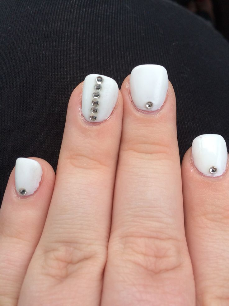 Chic White Nail Design with Glossy Finish and Modern Metallic Accents.