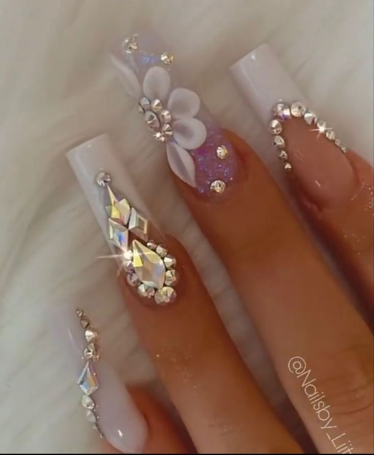 Glamorous Nail Design: Glossy White Tips with Rhinestones and Floral Accents for Special Occasions.