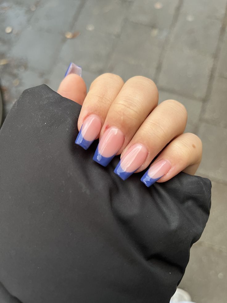 Elegant Ombre Nail Design: Soft Pinks and Bold Blue Tips in a Modern Squared Shape.