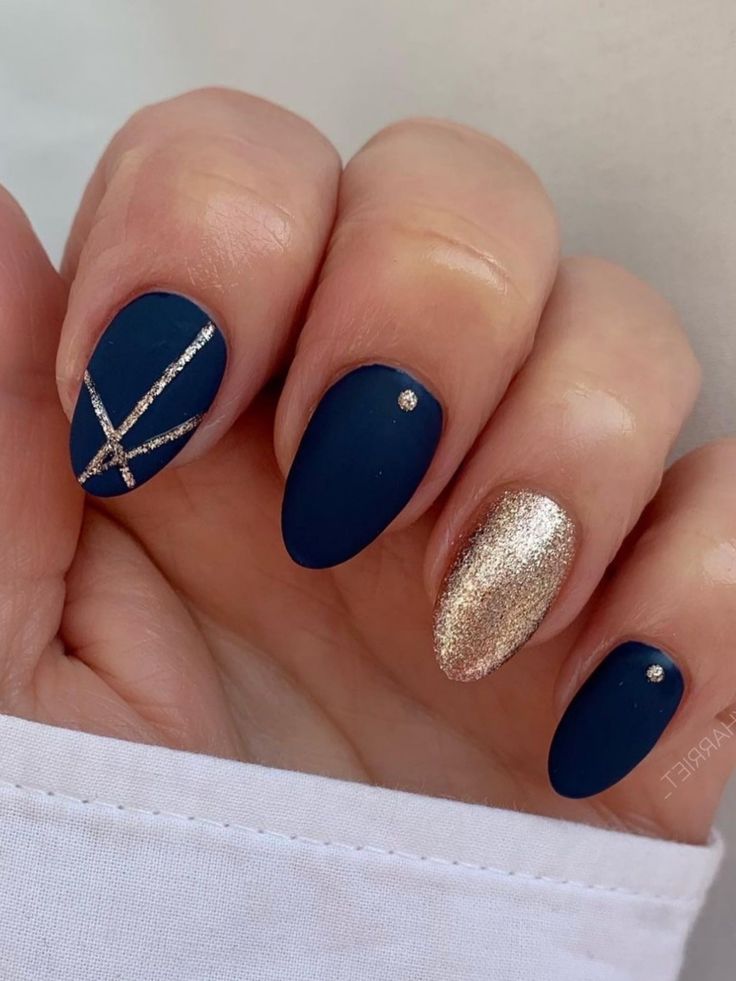 Chic navy matte nail design with gold accents and silver geometric patterns for a sophisticated look.