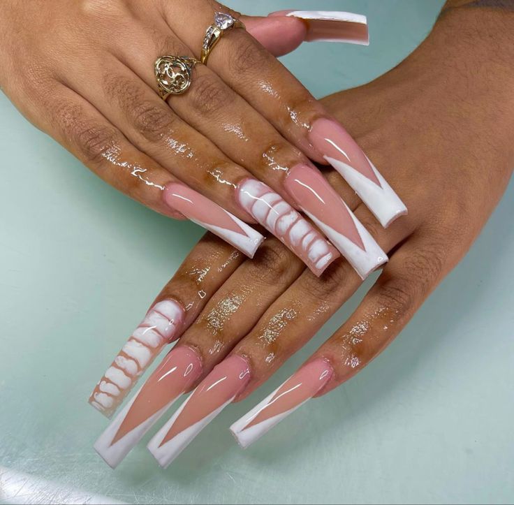 Elegant Long Sculpted Acrylic Nail Design in Nude and White with Intricate Detailing.